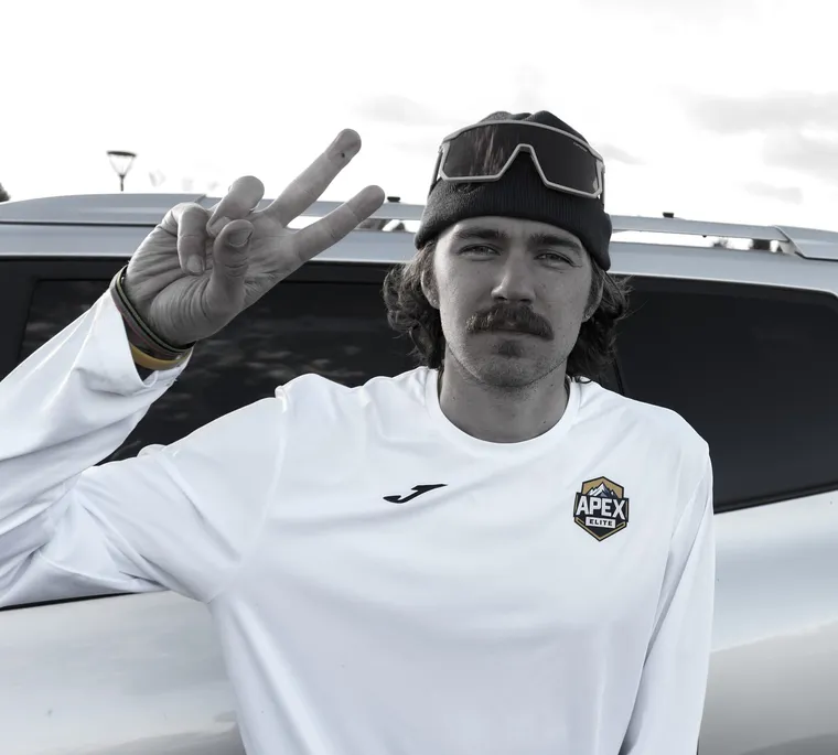 An Apex Elite coach flashing a peace sign after practice