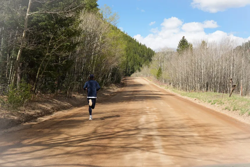 A runner alone on a dirt road in the Colorado high country