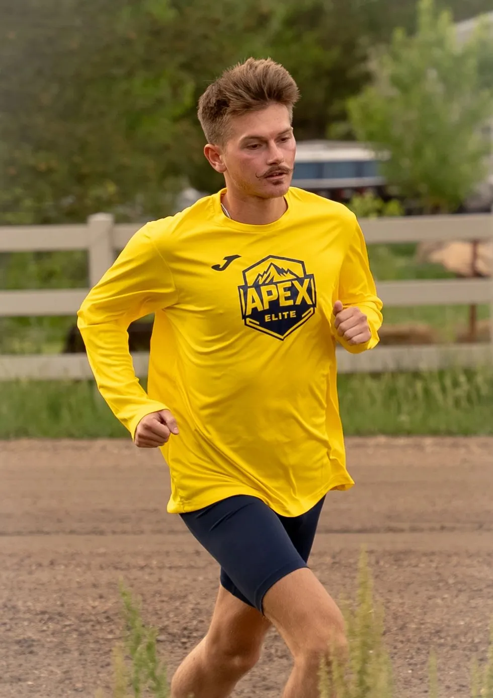 Apex Elite athlete on a training run in a gold team shirt